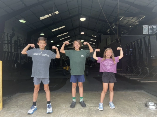 Kids flexing at Koda CrossFit Central strength camp